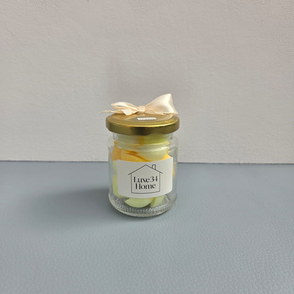 Luxe 34 Home ylang ylang wax melts close up in glass jar with gold lid and cream ribbon