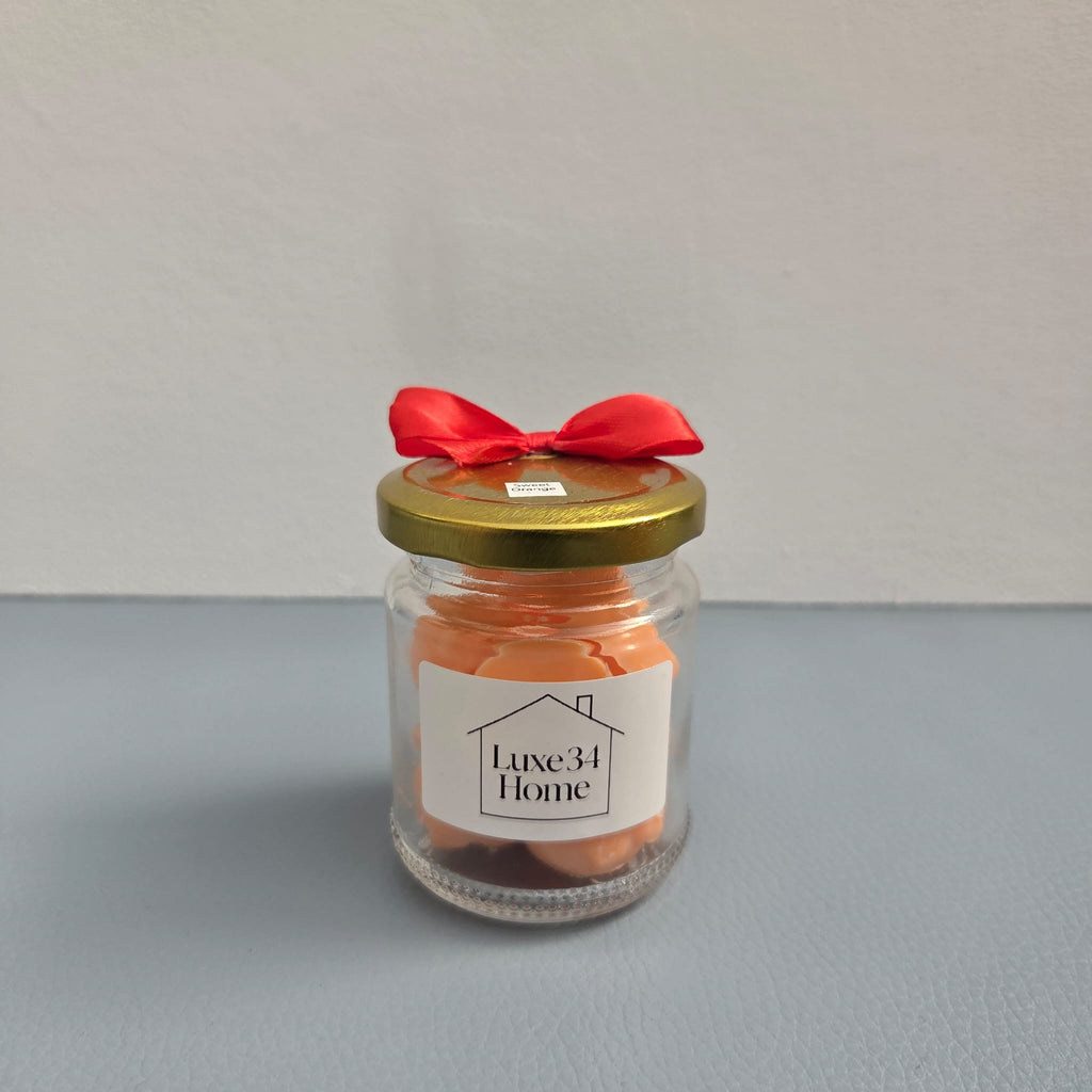 Luxe 34 Home sweet orange wax melts in glass jar with orange wax melts, gold lid and red ribbon bow