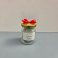 Luxe 34 Home pine needle wax melts in glass jar with sage green wax melts, gold lid and red ribbon bow