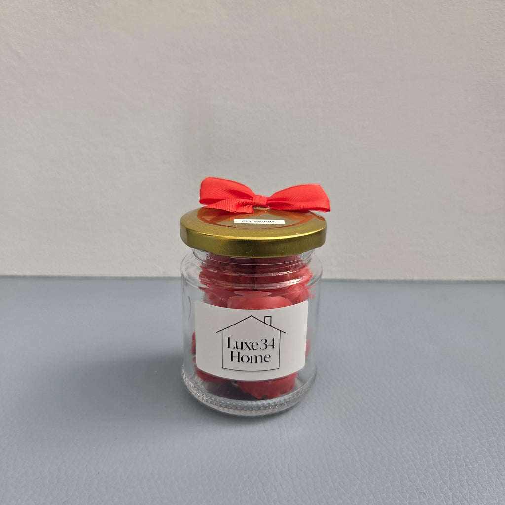 Luxe 34 Home cinnamon wax melts in glass jar with deep red wax melts, gold lid and red ribbon bow